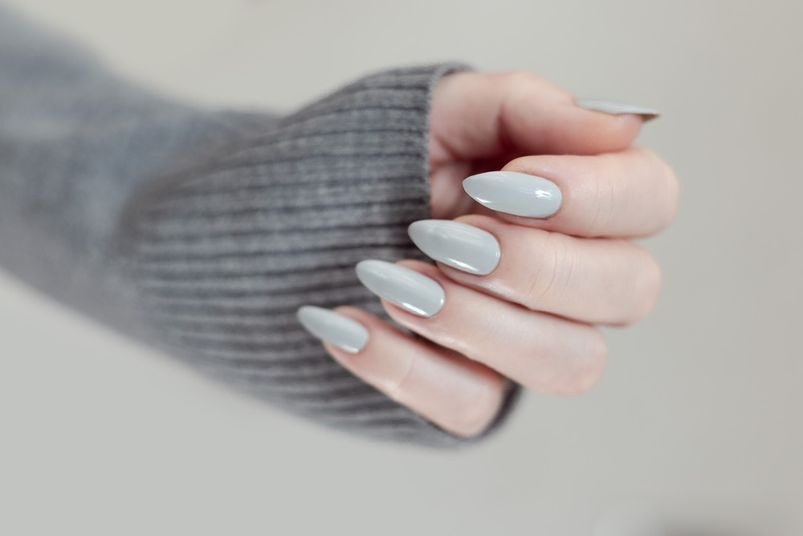 mano de mujer con uñas grises